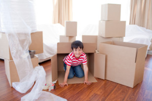 Kid playing with boxes in new house